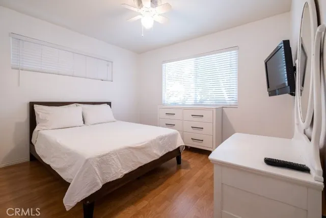 a bedroom with a bed and a flat tv screen on dresser