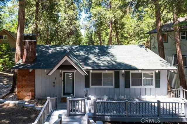 a view of house with roof deck and garden