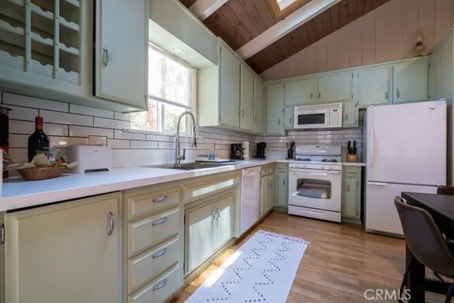 a kitchen with cabinets stainless steel appliances a sink and a window