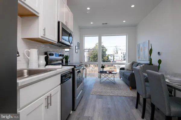 a kitchen with stainless steel appliances granite countertop sink stove top oven and cabinets