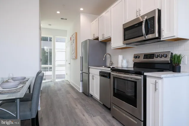 a kitchen with stainless steel appliances granite countertop a stove microwave and cabinets