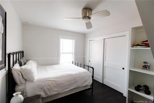 a bedroom with a bed and a ceiling fan
