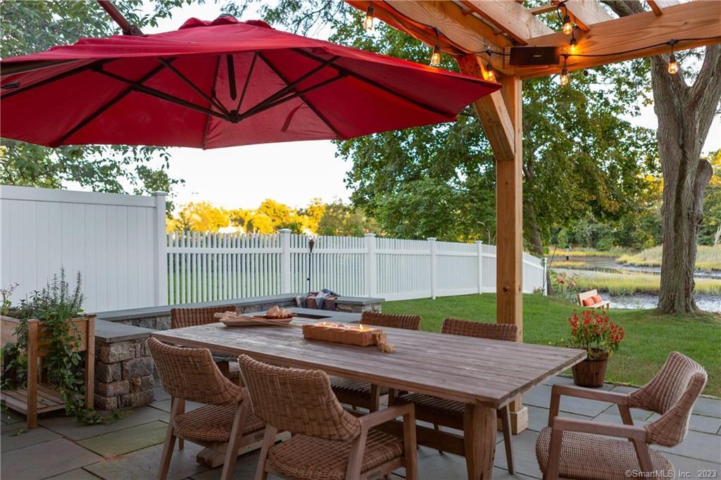 331 Riverside Drive Fairfield, CT 06824 - Photo 28 of 34 a patio with a table and chairs under an umbrella