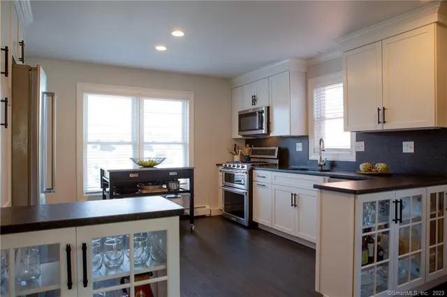 a kitchen with stainless steel appliances granite countertop a stove a sink and a refrigerator