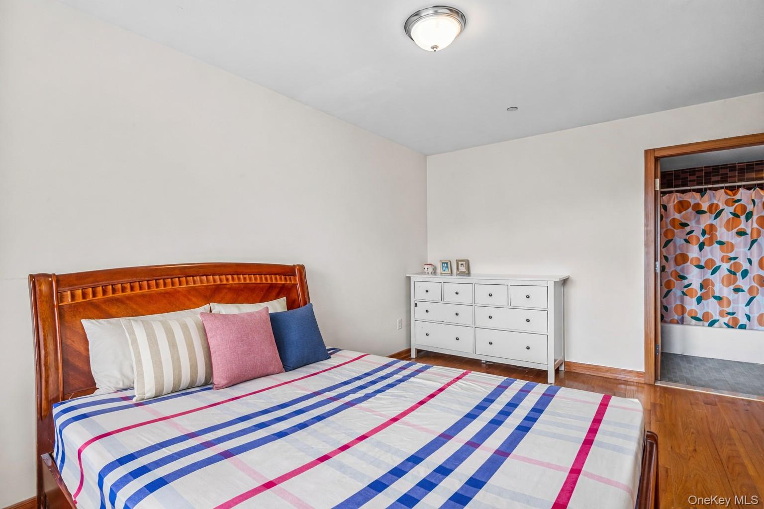 37-17 111th Street, Unit 4F Queens, NY 11368 - Photo 12 of 19 a bedroom with a bed and painting on the wall