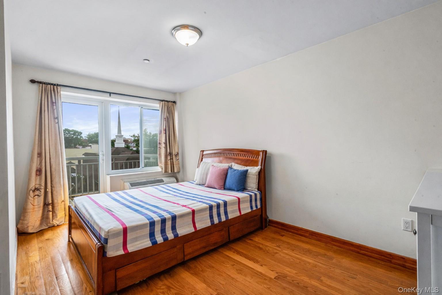 37-17 111th Street, Unit 4F Queens, NY 11368 - Photo 10 of 19 a bedroom with a bed and wooden floor