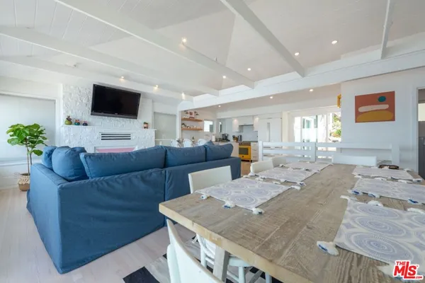 a view of a dining room with furniture a chandelier and wooden floor