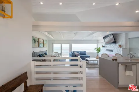 a kitchen with a sink stove cabinets and wooden floor