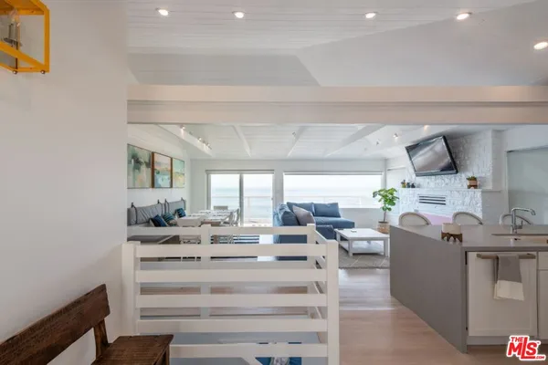 a kitchen with a sink stove cabinets and wooden floor