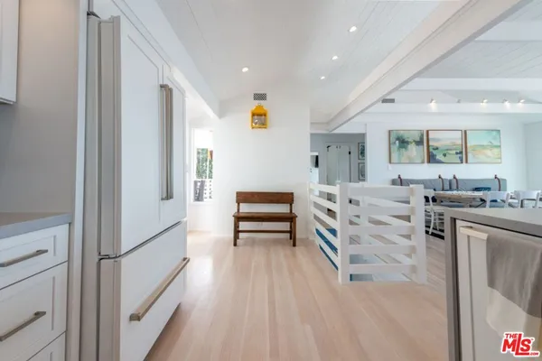 a kitchen with stainless steel appliances granite countertop a sink a stove a refrigerator and island with wooden floor