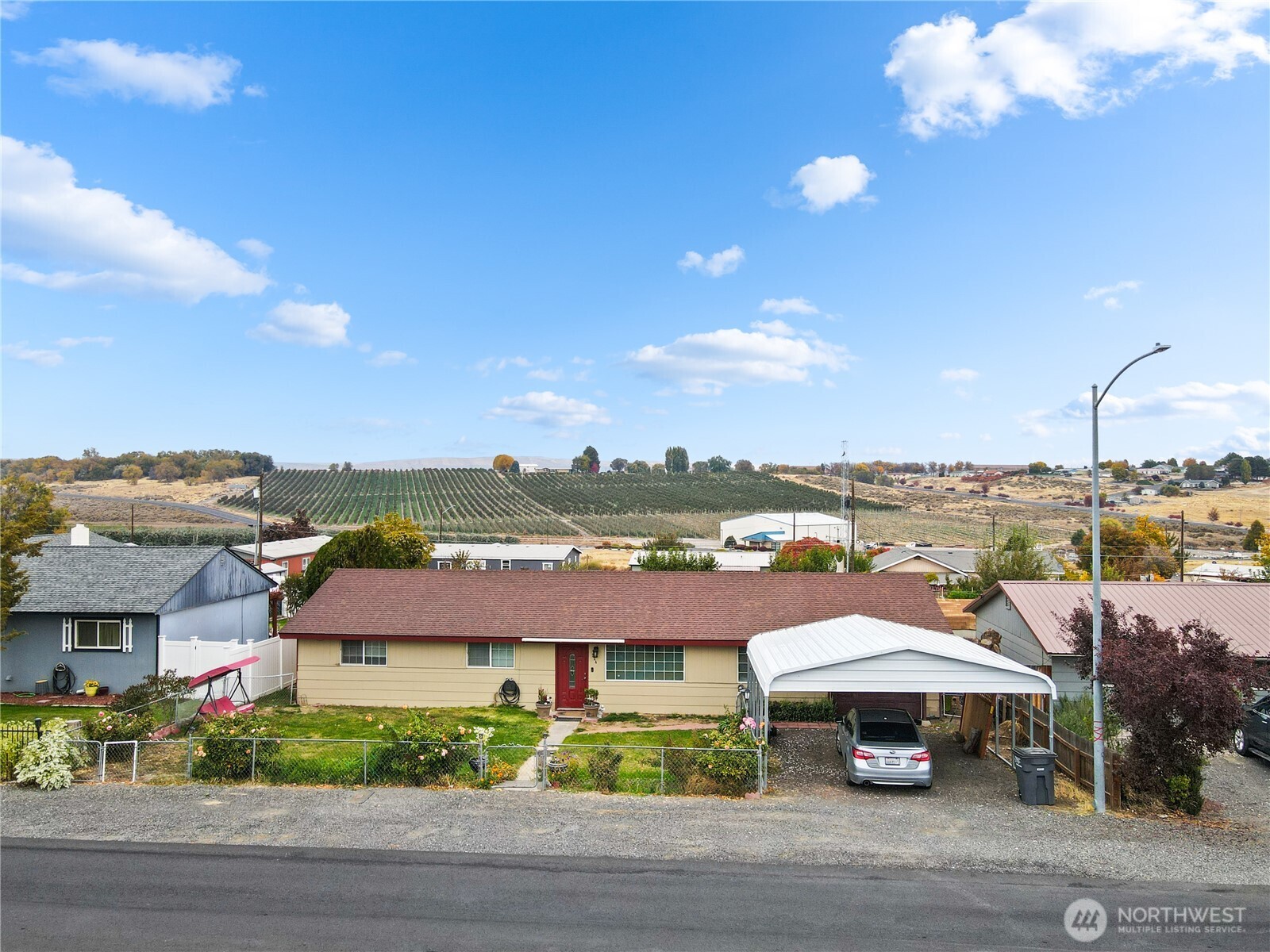 224 Calla Loop Northwest Royal City, WA 99357 - Photo 2 of 28 a view of a big house with a big yard and table and chairs under an umbrella