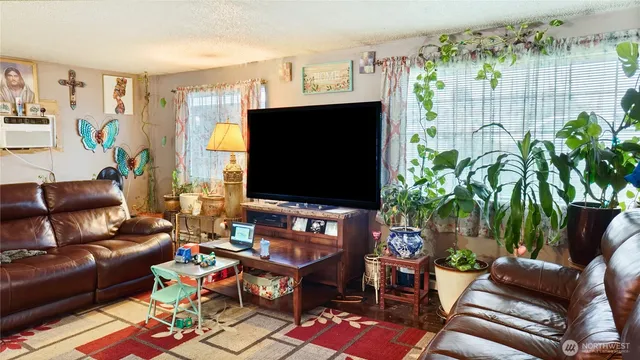 a living room with furniture a flat screen tv and a floor to ceiling window