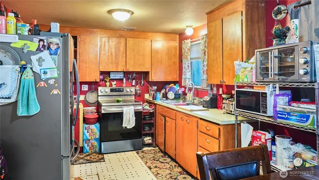 a kitchen with stainless steel appliances kitchen island granite countertop a sink and a refrigerator