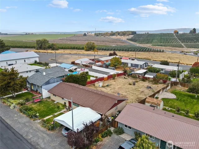 an aerial view of ocean and residential houses with outdoor space