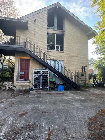 a view of a house with a yard and parking space
