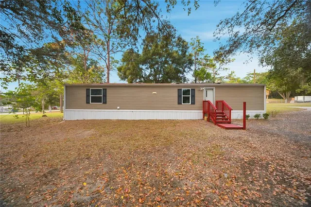 a view of a house with backyard and tree