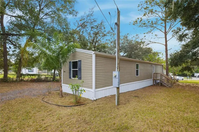 a view of a house with a backyard and tree