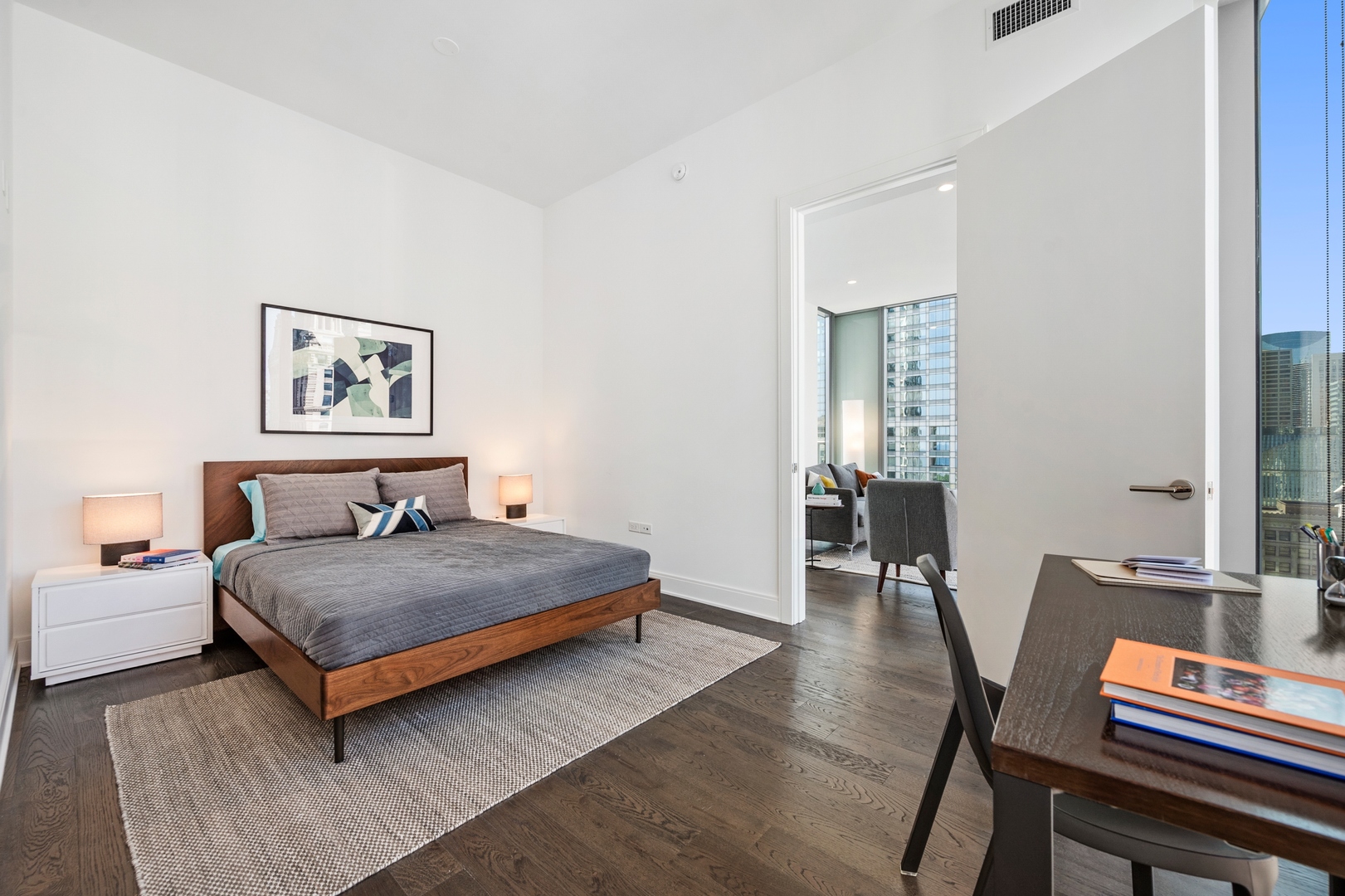 60 East Randolph Street, Unit 23B Chicago, IL 60601 - Photo 11 of 27 a bedroom with a bed and wooden floor