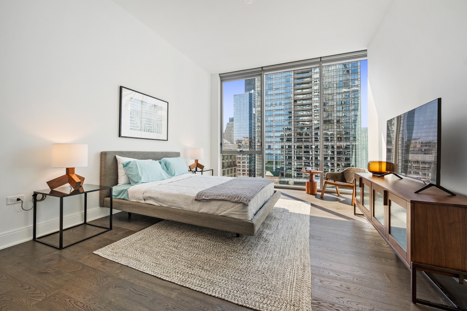 60 East Randolph Street, Unit 23B Chicago, IL 60601 - Photo 13 of 27 a bedroom with a bed and wooden floor