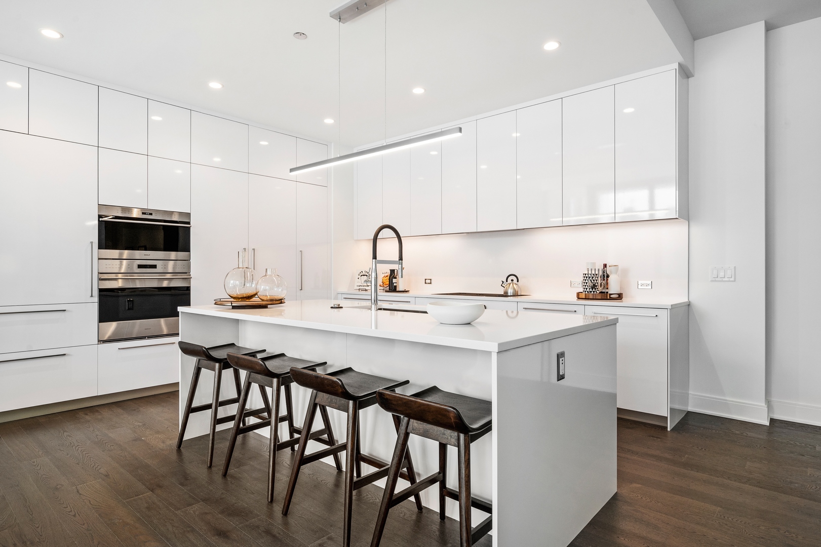 60 East Randolph Street, Unit 23B Chicago, IL 60601 - Photo 6 of 27 a kitchen with a sink white cabinets and stainless steel appliances
