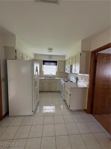 a kitchen with a sink a refrigerator and cabinets