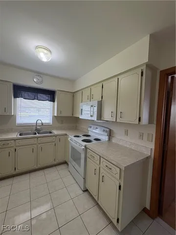 a kitchen with a sink stove and cabinets