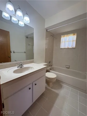 a bathroom with a granite countertop sink a toilet and a bathtub