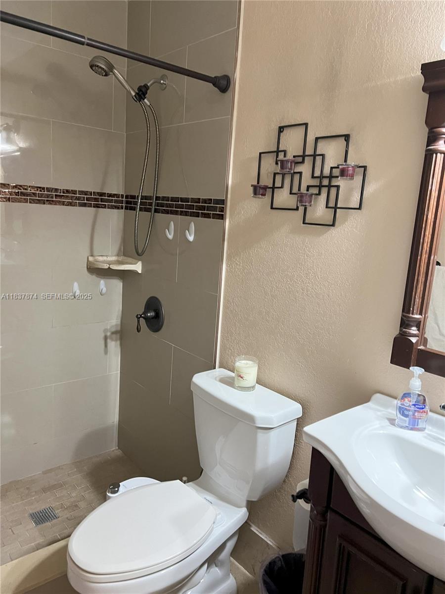 12554 Southwest 211th Terrace Miami, FL 33177 - Photo 13 of 30 a white toilet sitting next to a bathroom sink