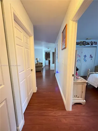 a view of a hallway with wooden floor and furniture