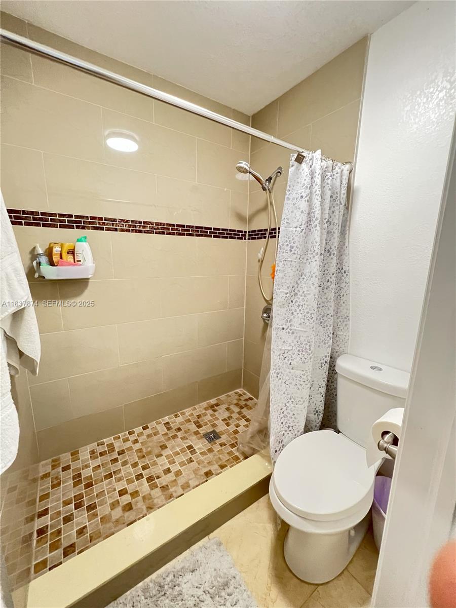 12554 Southwest 211th Terrace Miami, FL 33177 - Photo 22 of 30 a bathroom with a toilet and shower
