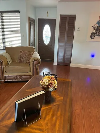 a living room with furniture and a wooden floor
