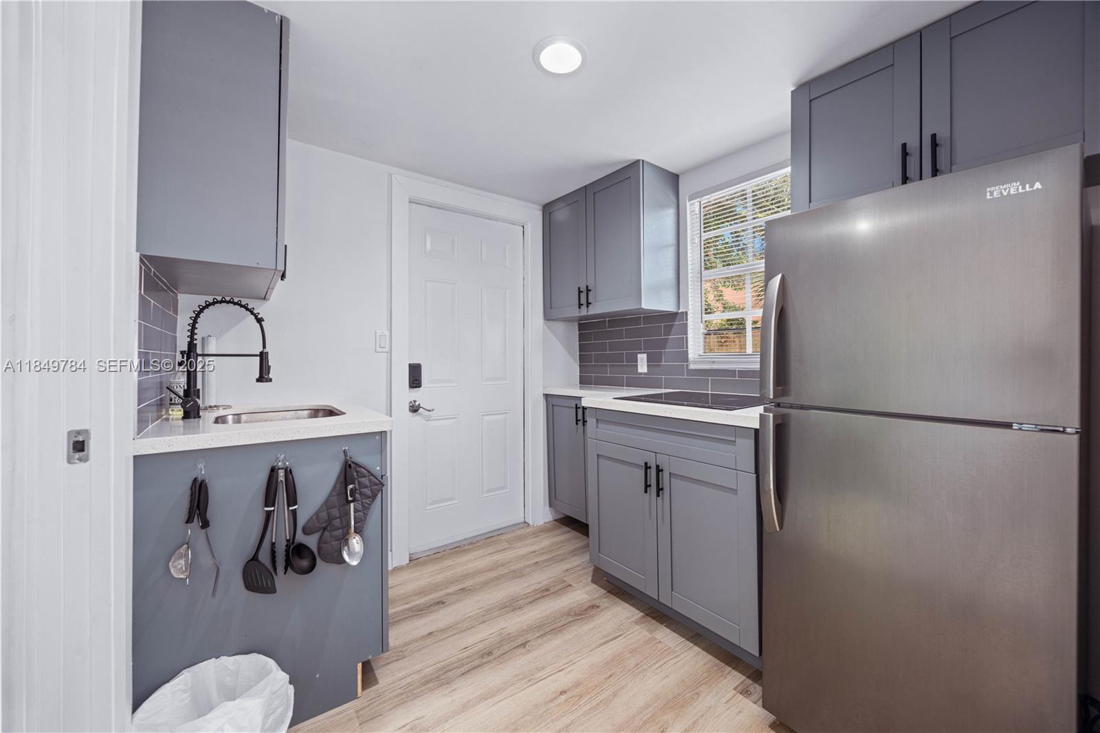 790 Northwest 63rd Street Miami, FL 33150 - Photo 18 of 35 a kitchen with a refrigerator sink and cabinets