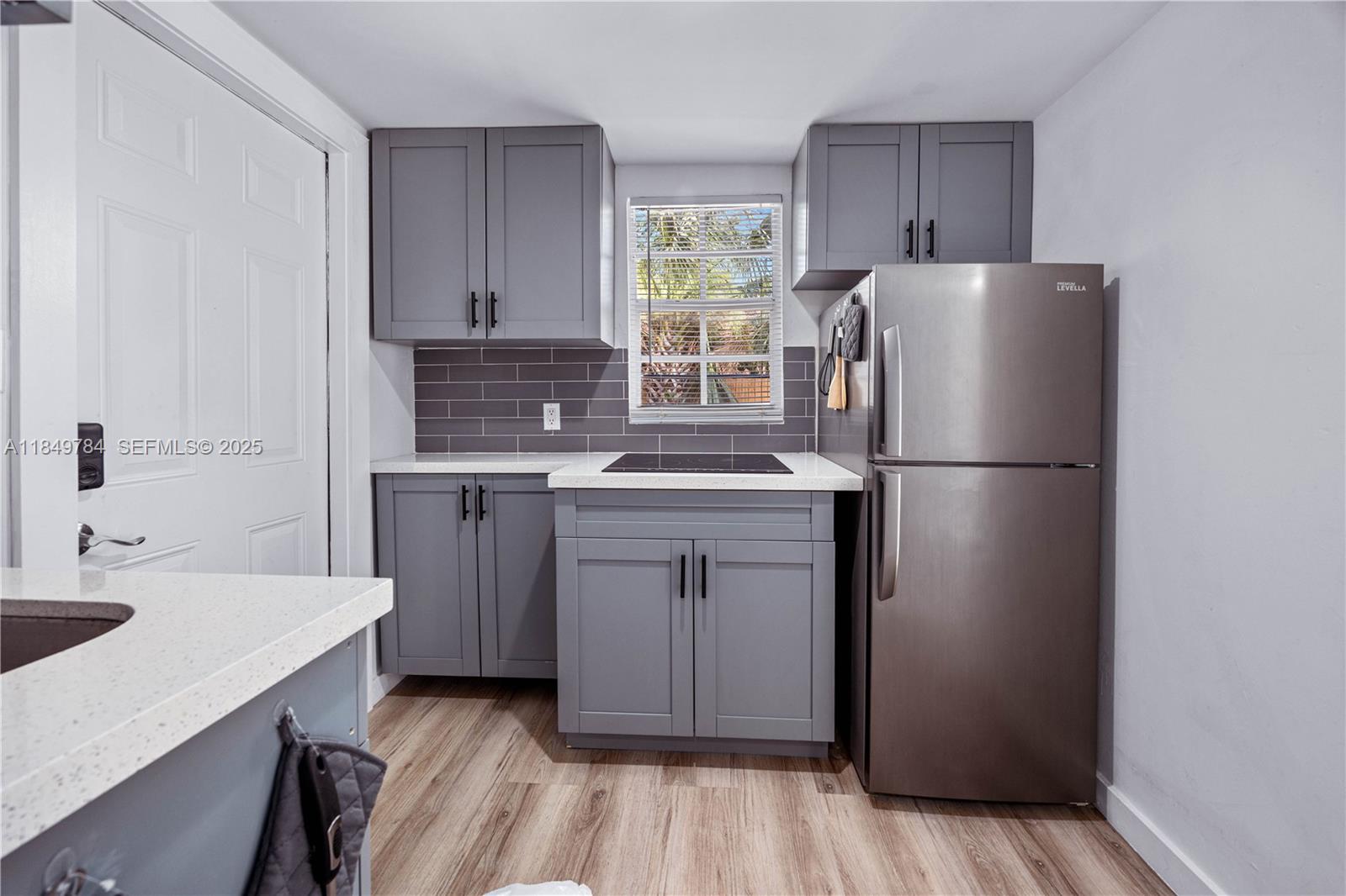 790 Northwest 63rd Street Miami, FL 33150 - Photo 20 of 35 a kitchen with a refrigerator sink and cabinets