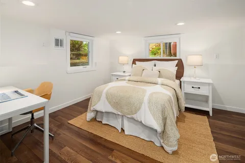 a bedroom with a bed and paintings on the wall