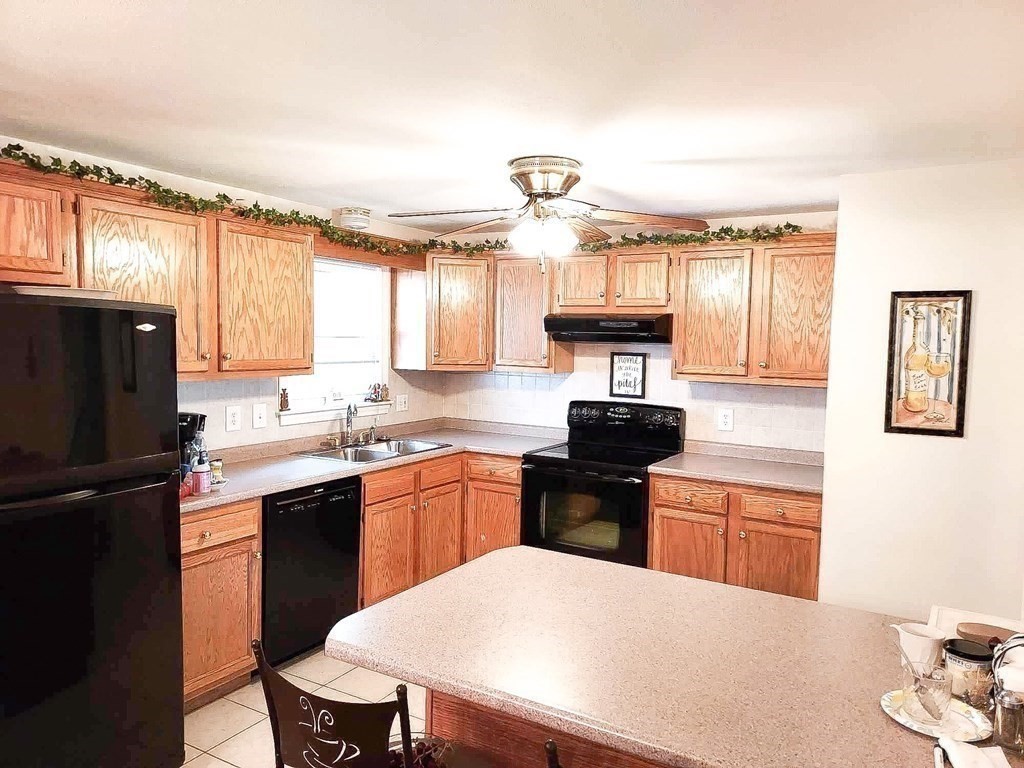 37 Heritage Road Billerica, MA 01821 - Photo 7 of 24 a kitchen with a stove a sink and a refrigerator