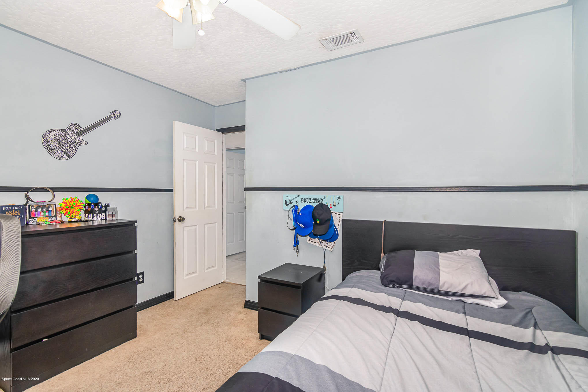 484 Rheine Road Northwest Palm Bay, FL 32907 - Photo 17 of 24 a bedroom with a bed and a chandelier