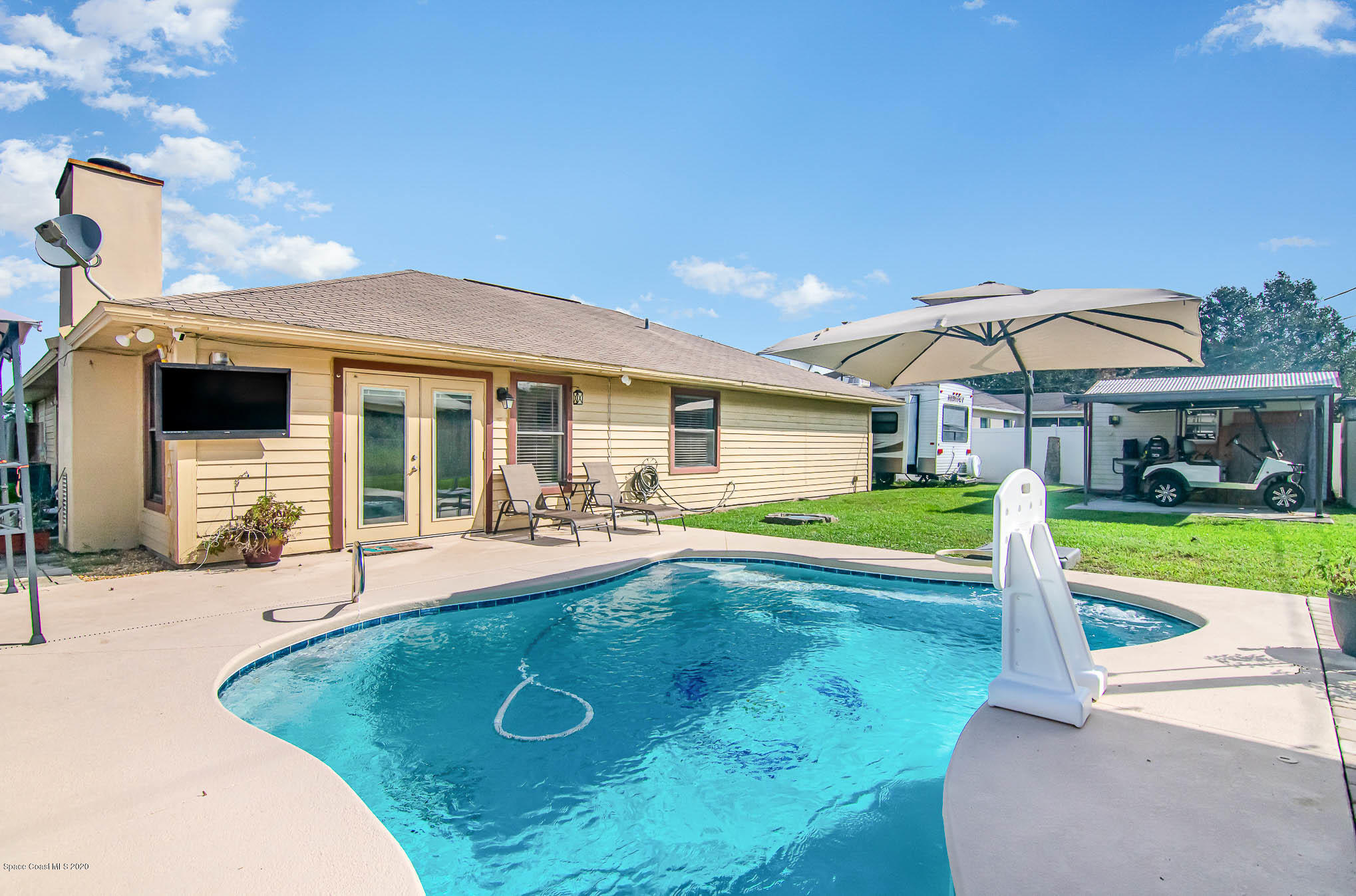 484 Rheine Road Northwest Palm Bay, FL 32907 - Photo 20 of 24 a view of a house with swimming pool and a yard