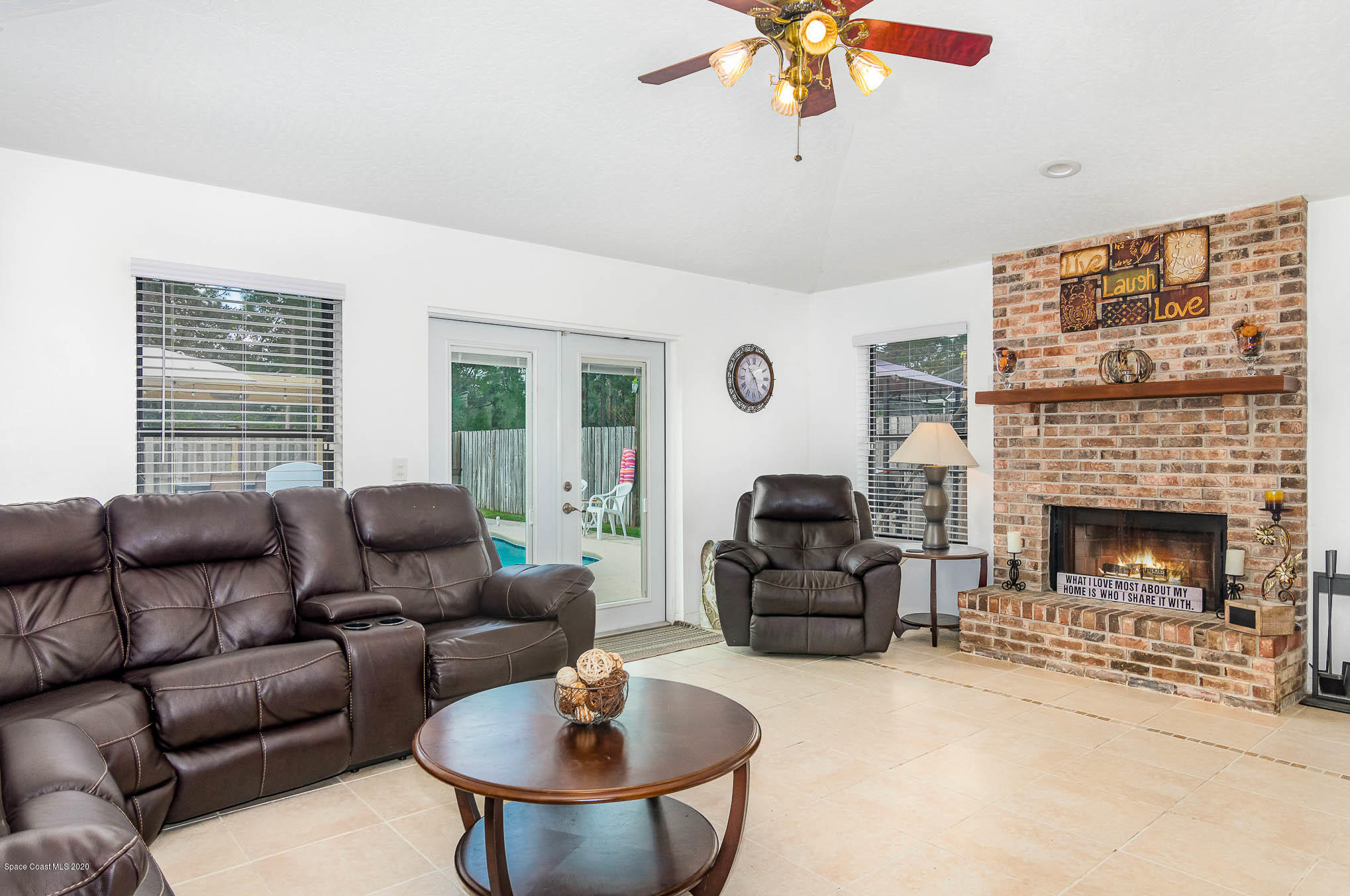 484 Rheine Road Northwest Palm Bay, FL 32907 - Photo 3 of 24 a living room with furniture a fireplace and a flat screen tv