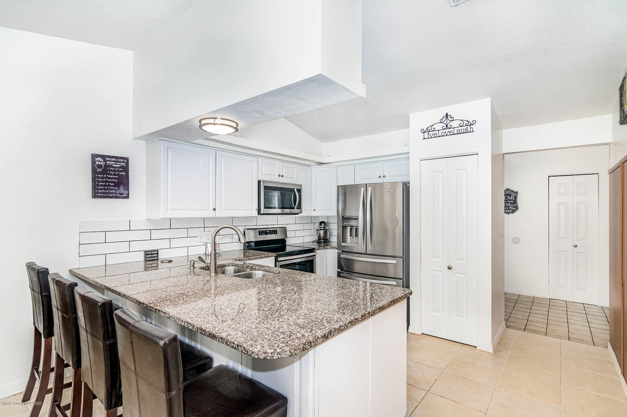 484 Rheine Road Northwest Palm Bay, FL 32907 - Photo 8 of 24 a kitchen with stainless steel appliances granite countertop a sink refrigerator and microwave