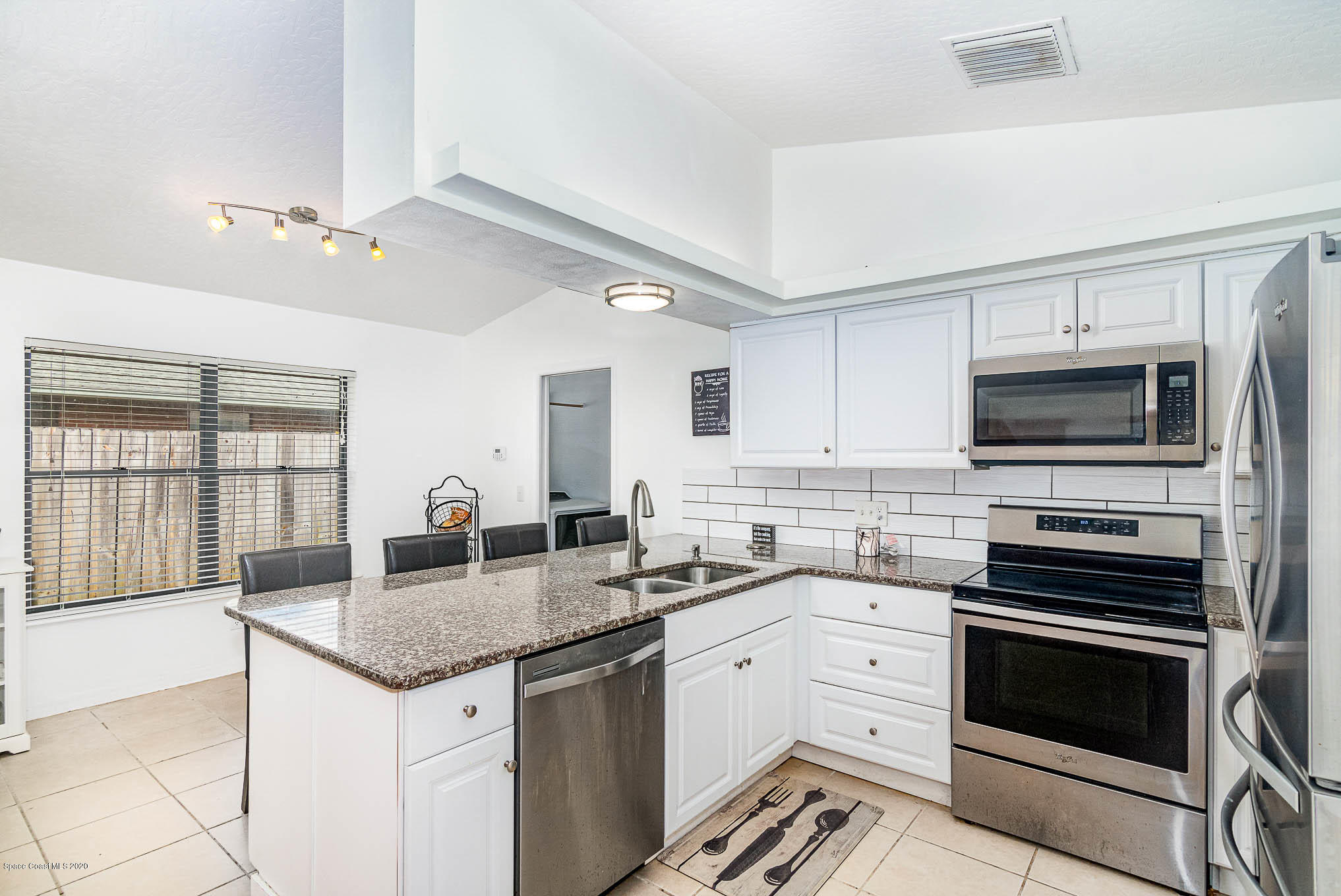 484 Rheine Road Northwest Palm Bay, FL 32907 - Photo 9 of 24 a kitchen with granite countertop a sink stove and microwave