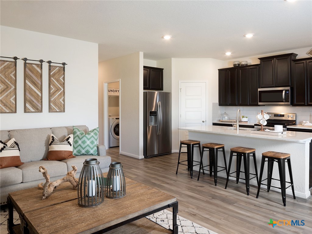 125 Dakota Ridge Cibolo, TX 78108 - Photo 3 of 13 a living room with stainless steel appliances kitchen island granite countertop furniture and a wooden floor