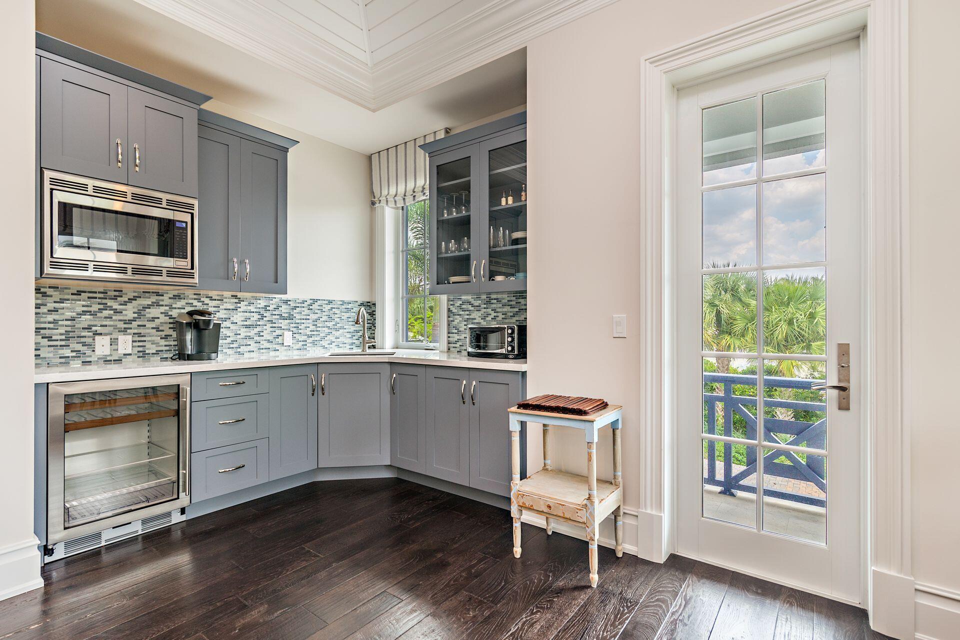1222 North Ocean Boulevard Gulf Stream, FL 33483 - Photo 24 of 61 a kitchen with granite countertop wooden floors and white stainless steel appliances
