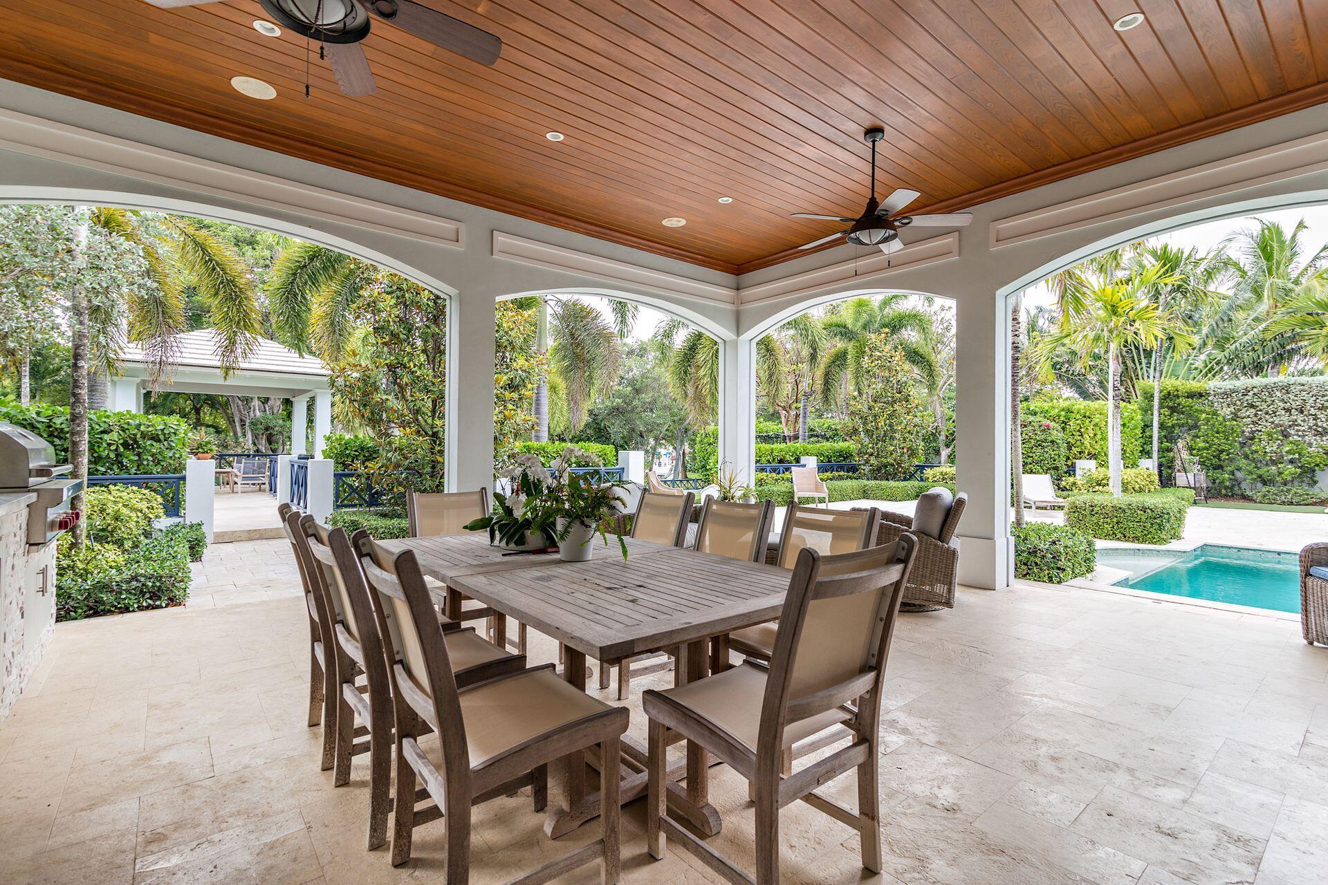 1222 North Ocean Boulevard Gulf Stream, FL 33483 - Photo 29 of 61 a view of a patio with a table chairs and a backyard