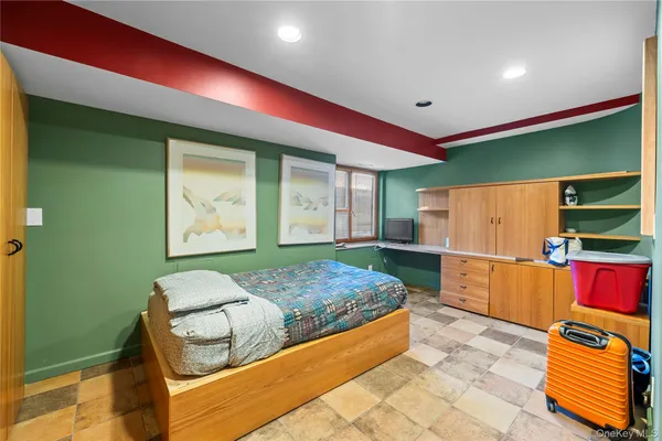 a bedroom with a bed and a refrigerator