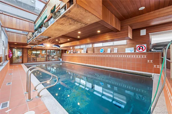 an aerial view of a swimming pool with outdoor seating