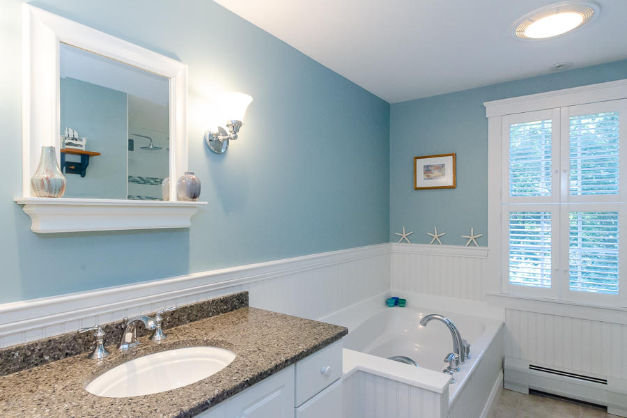 18 Register Road Marion, MA 02738 - Photo 19 of 30 a bathroom with a granite countertop tub a double vanity sink and mirror