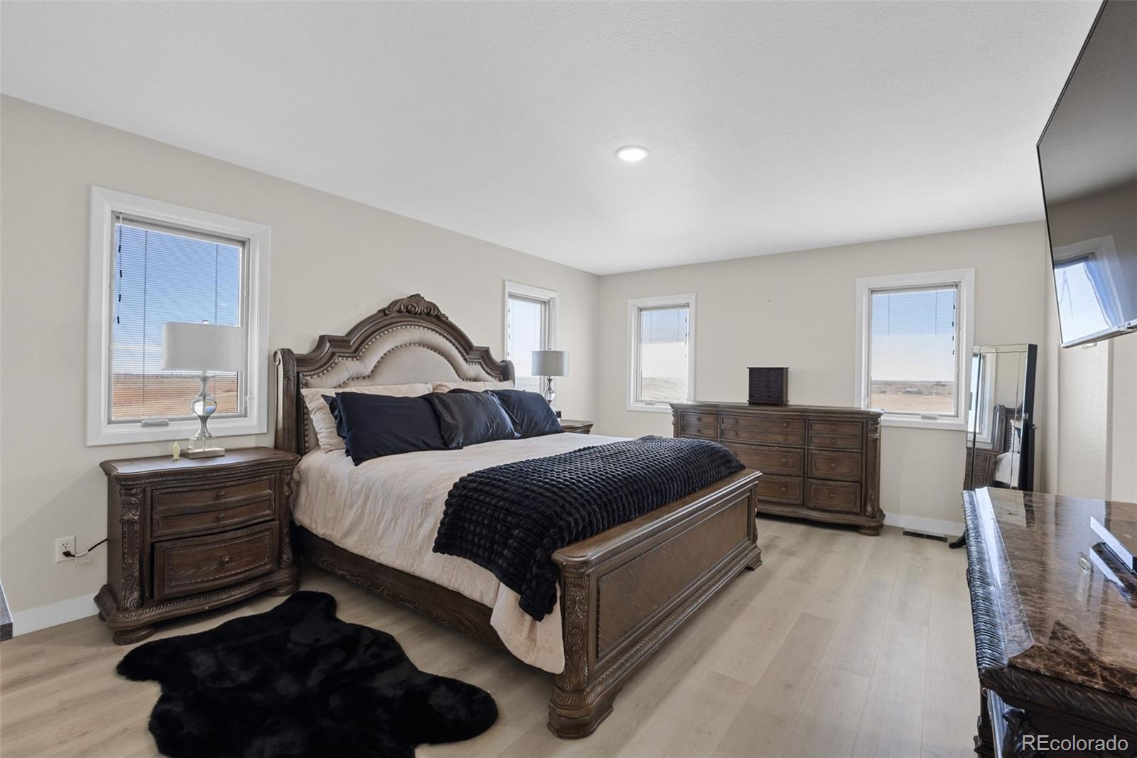 5330 Kiowa-Bennett Road Bennett, CO 80102 - Photo 22 of 50 a bedroom with a bed and dresser with mirror