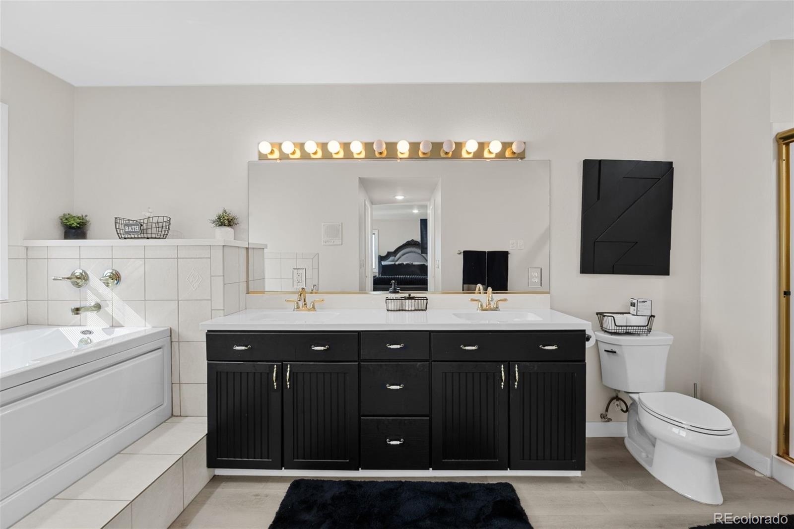 5330 Kiowa-Bennett Road Bennett, CO 80102 - Photo 24 of 50 a spacious bathroom with a double vanity sink and a mirror