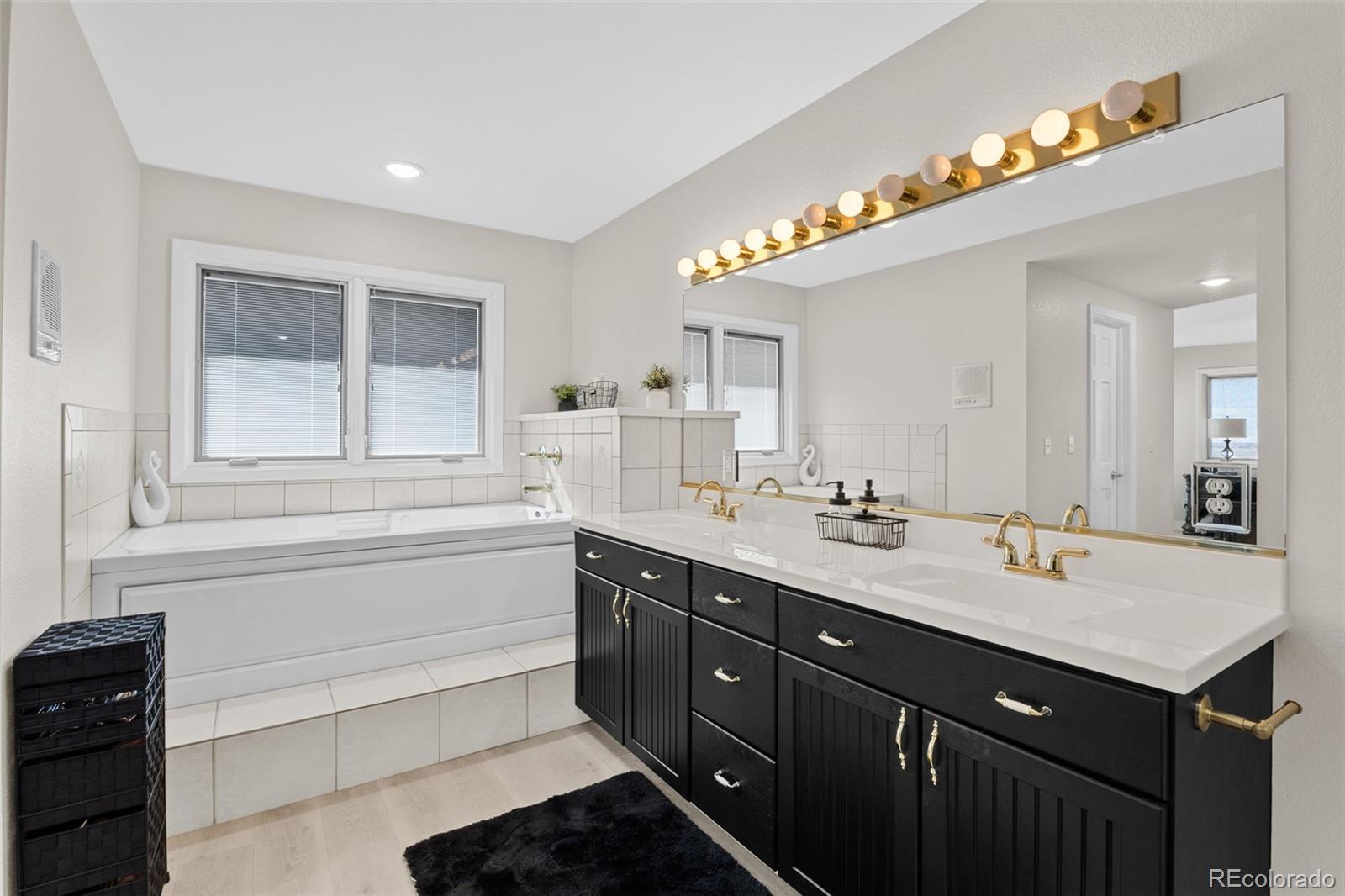 5330 Kiowa-Bennett Road Bennett, CO 80102 - Photo 25 of 50 a bathroom with a sink double vanity and a mirror