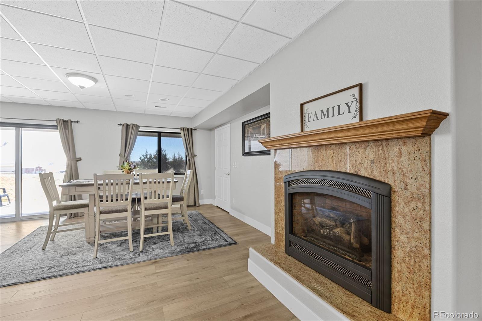 5330 Kiowa-Bennett Road Bennett, CO 80102 - Photo 30 of 48 a dining room with furniture and a fireplace